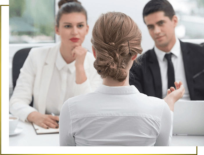 A woman is sitting at the head of a table